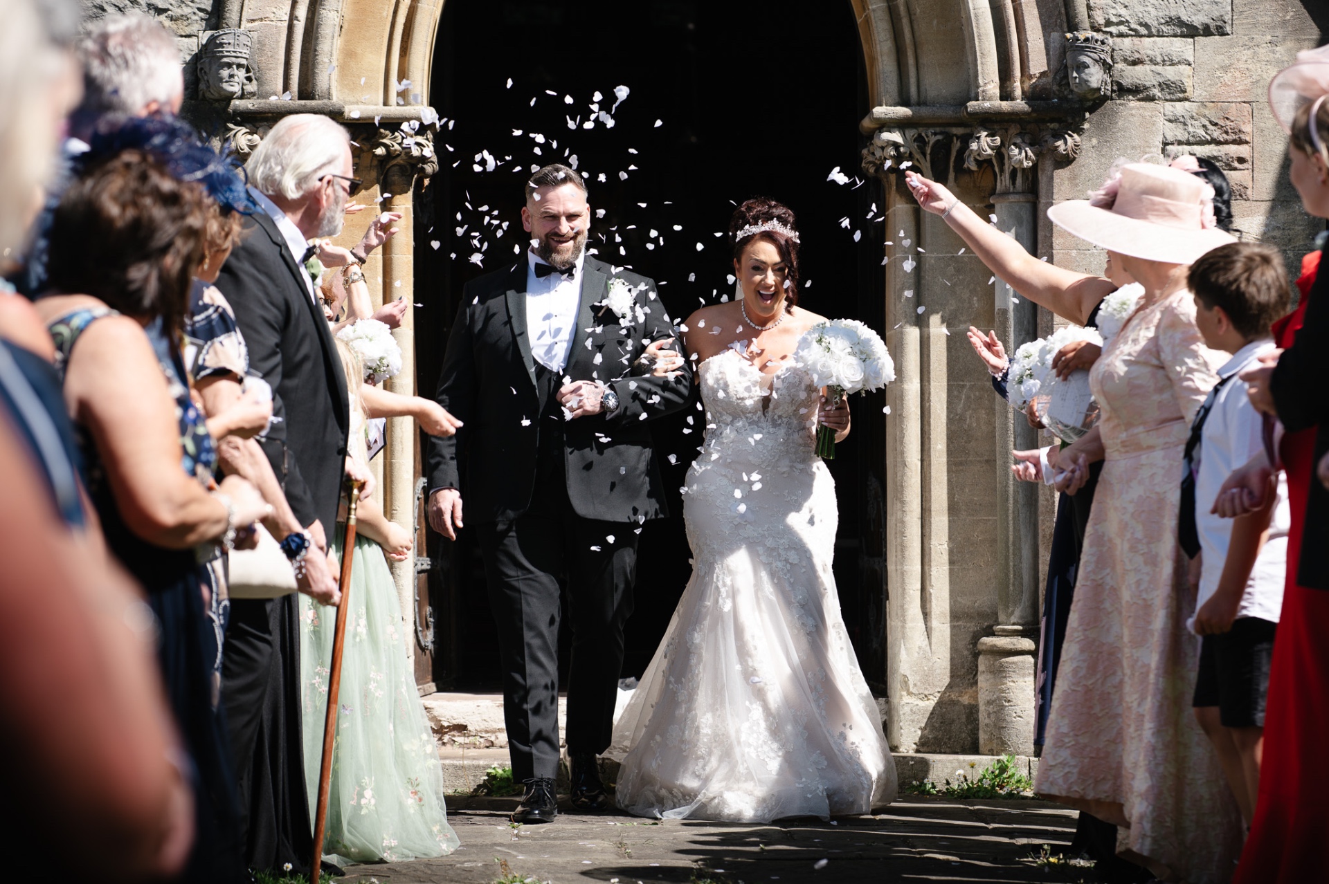 Bride and groom showered with confetti as they leave the church — Worcestershire wedding photography