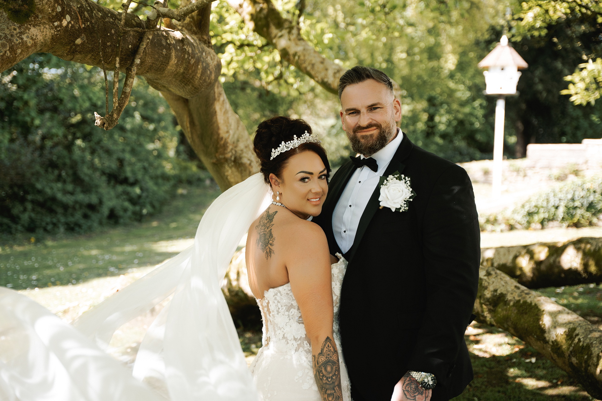 Bride and groom portrait beside a sunlit tree in a Worcestershire garden, veil flowing in the breeze, wedding photography Worcestershire & Midlands