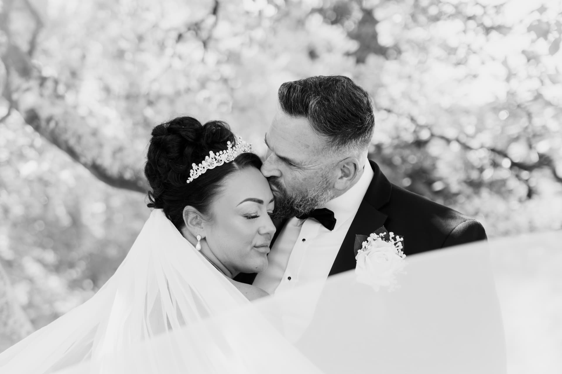 Bride and groom sharing a quiet moment beneath the trees in black and white, wedding photography Worcestershire & Midlands